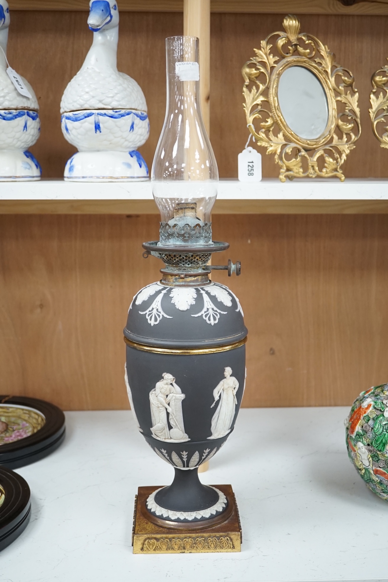 A Victorian black jasper oil lamp and reservoir, 65cm high. Condition - repaired at stem